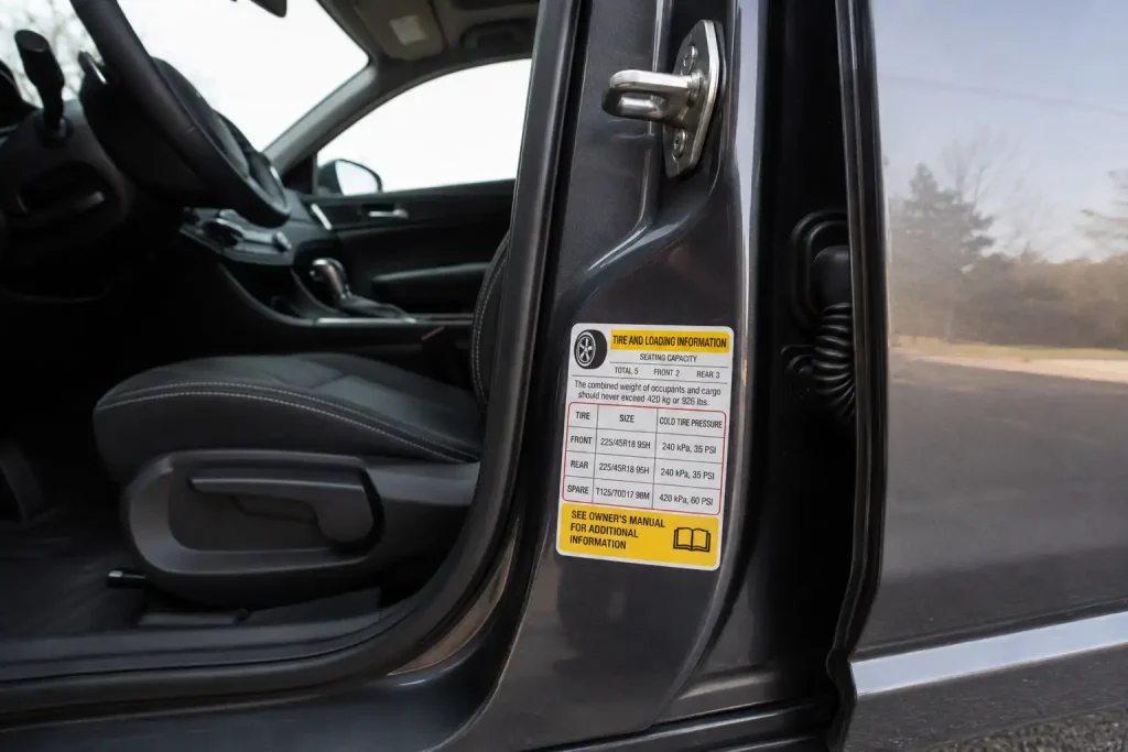 Driver-side doorjamb label showing what PSI to set a tire inflator to