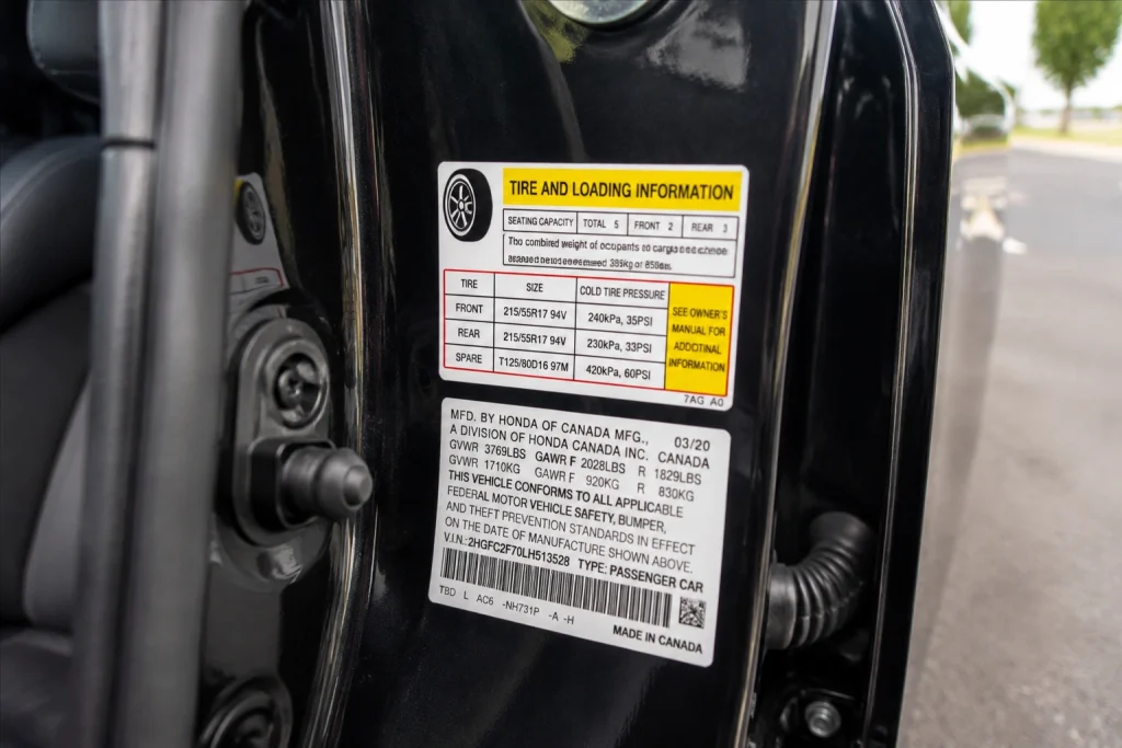 Driver door label showing recommended PSI before using a tire inflator at a gas station